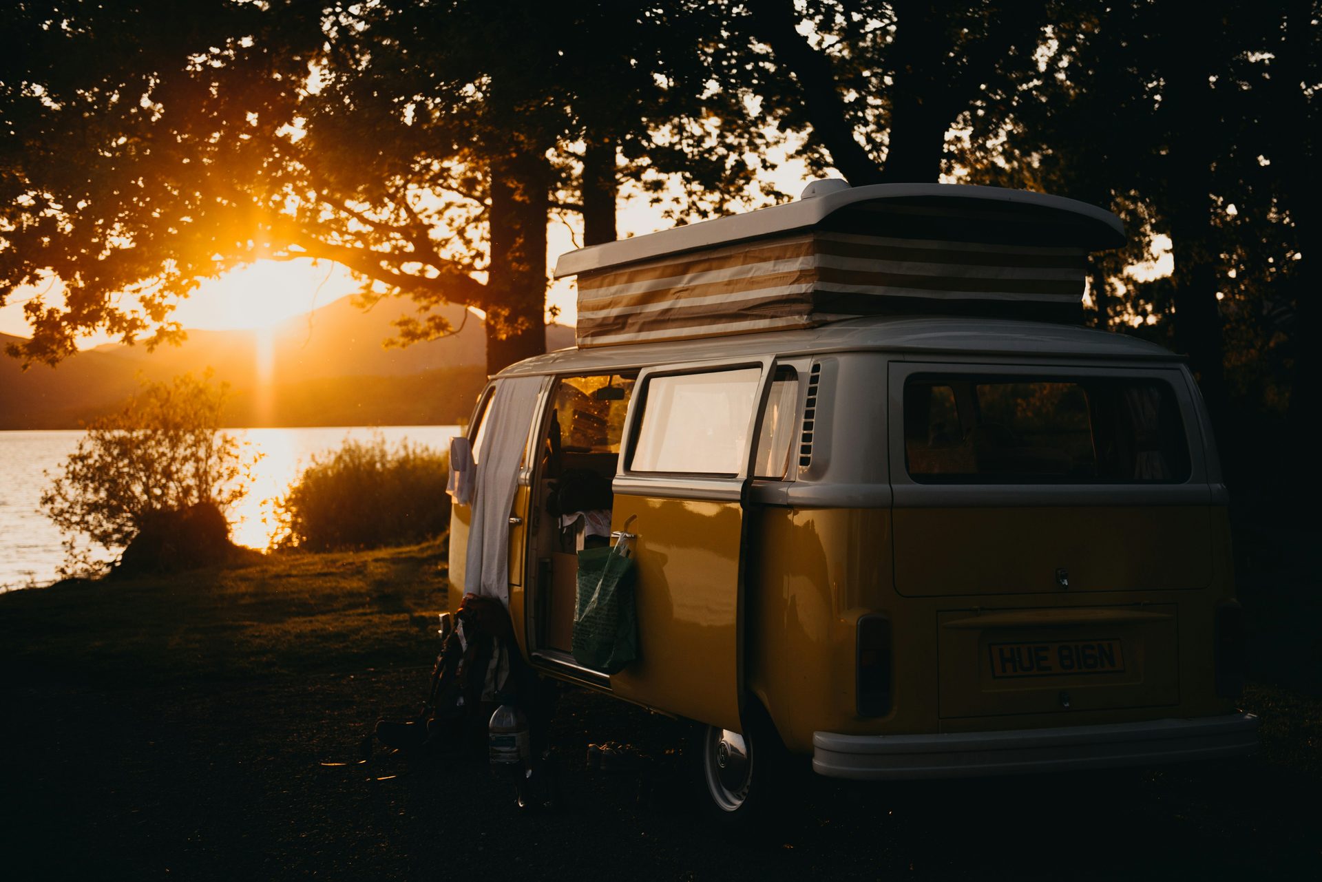 A vintage VW van parked at sunset by a lake